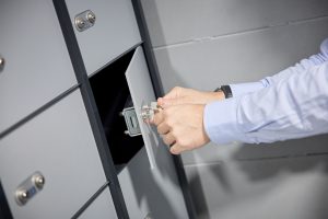 Unas manos de un hombre abren una caja de seguridad mediante dos llaves