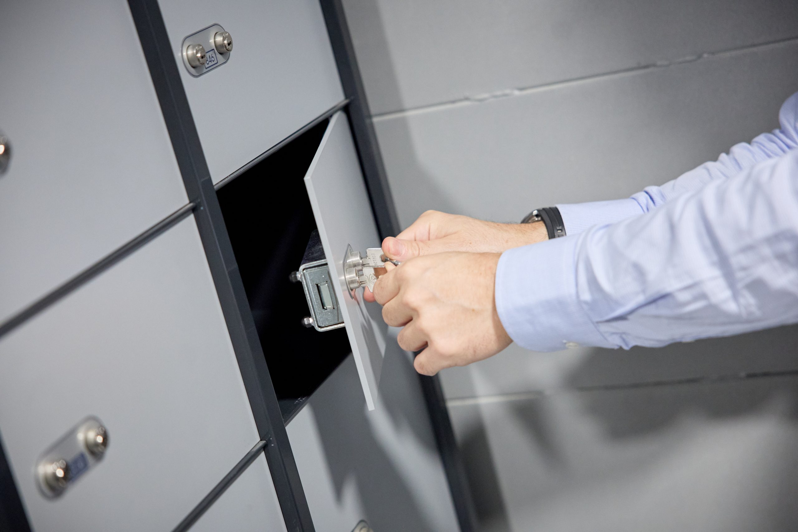 Unas manos de un hombre abren una caja de seguridad mediante dos llaves