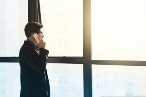 Un empresario habla por teléfono mientras mira a través de una ventana